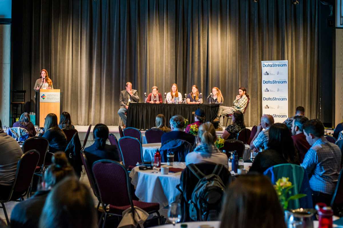 View from the audience at a group of panelists on stage