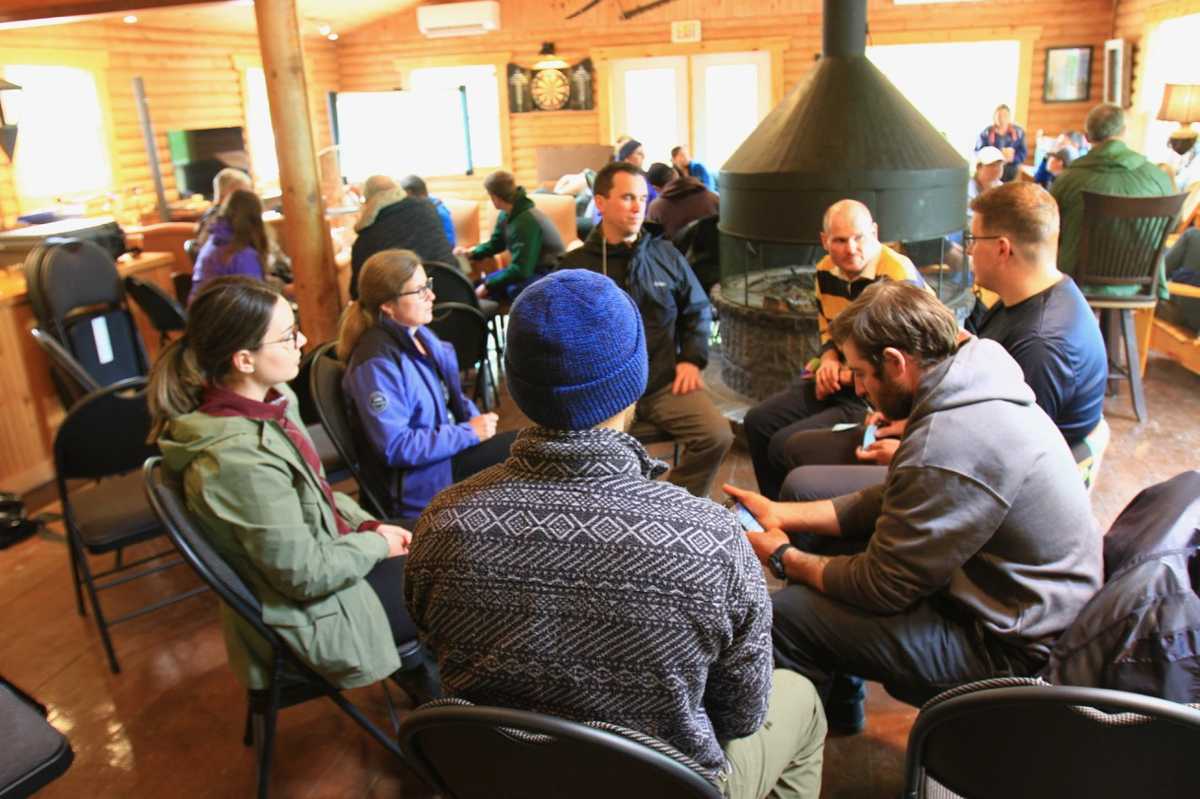 Group of people sitting in a circle in a cabin