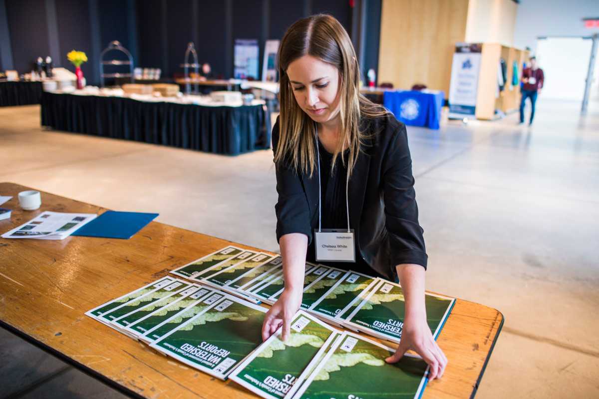 A woman lays out handouts on a table