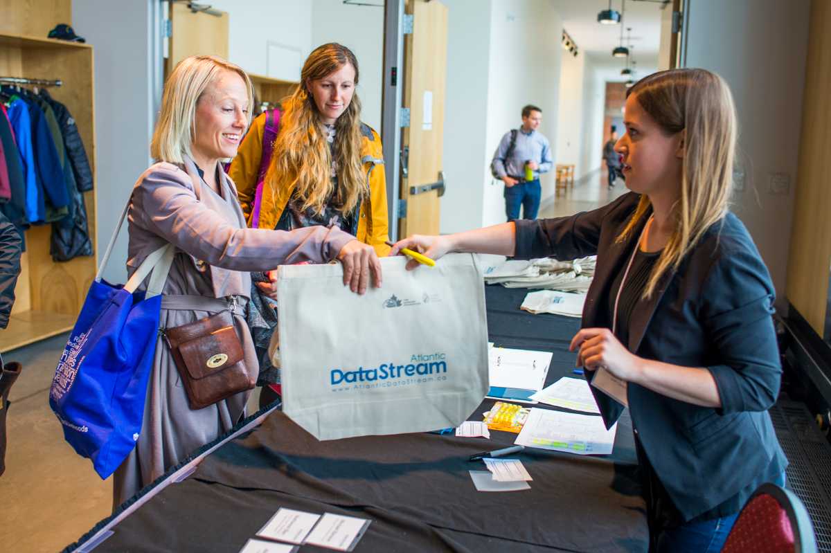 datastream kickoff participant receiving a tote bag at the registration table