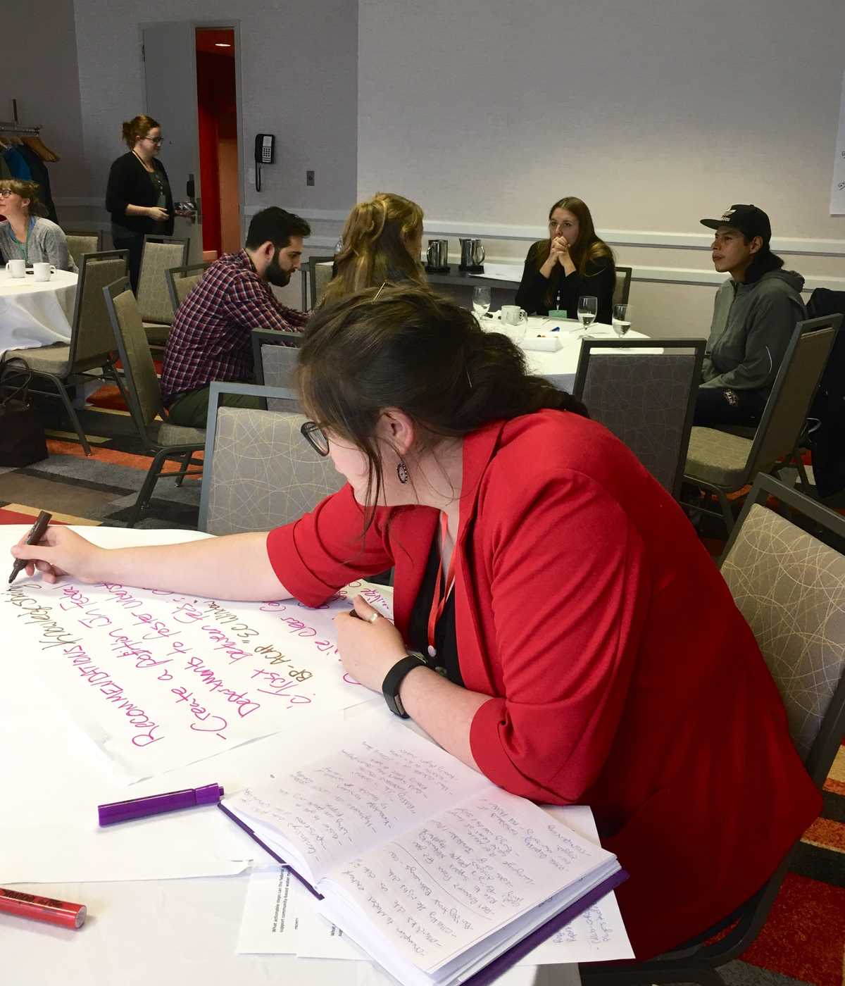 Emma Wattie rédige des notes lors d'une mini-table ronde